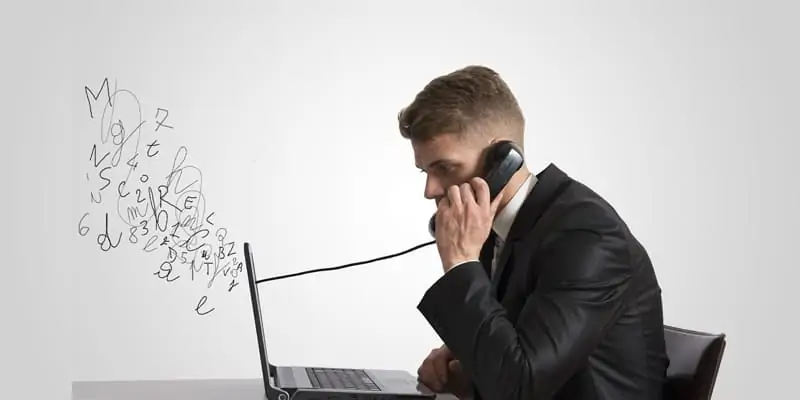 Person talking over a phone connected through laptop to depict small business VoIP service
